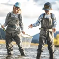 Wodery dziecięce Simms Kid's Tributary Stockingfoot Basalt – nad wodą z dorosłym